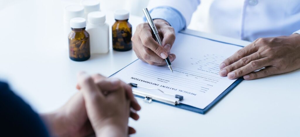 Doctor prescribing medication to a patient during a clinical consultation.