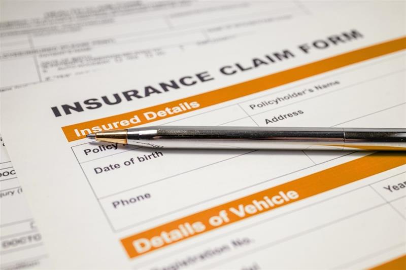 Insurance claim form with pen and details section