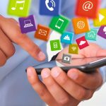 A person is holding a phone surrounded by social media content.